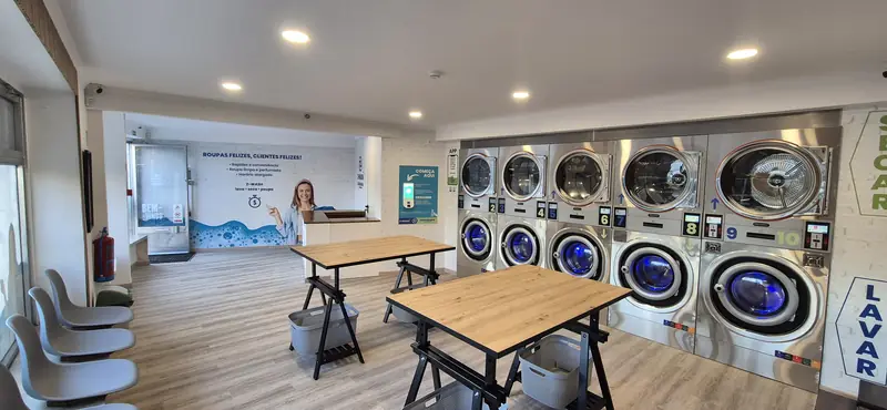 Interior da Z-WASH Odivelas: máquinas de lavar e secar, mesas para dobrar a roupa